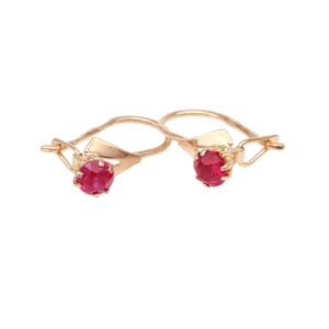 Two rose-gold rings, each with a round pink ruby held by prongs, on a white background