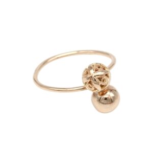 Gold ring with two beads: a hollow filigree bead and a smooth round bead on a slender band.