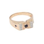 Gold ring with a central blue gemstone and small side diamonds, vintage-style band.