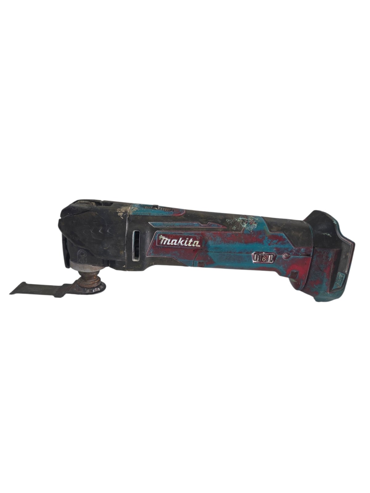 757de2c06cc173cf90756fa9f6e26fa7jpg - Mezola OÜ Cordless Makita oscillating multitool covered in dirt with blade attached, lying on its side on a white background