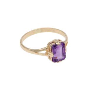 Gold ring with a rectangular-cut purple amethyst set in a decorative prong setting.