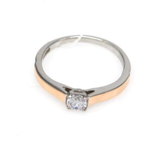 Two-tone ring with a rose gold band and silver setting, featuring a round diamond centerpiece.