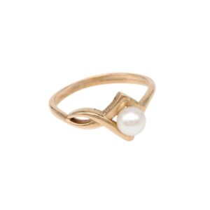 Gold ring with a small white pearl in a curved centerpiece design on a pale background.