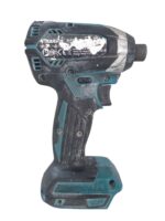 Cordless drill with teal and black casing, dirty and scratched from use.