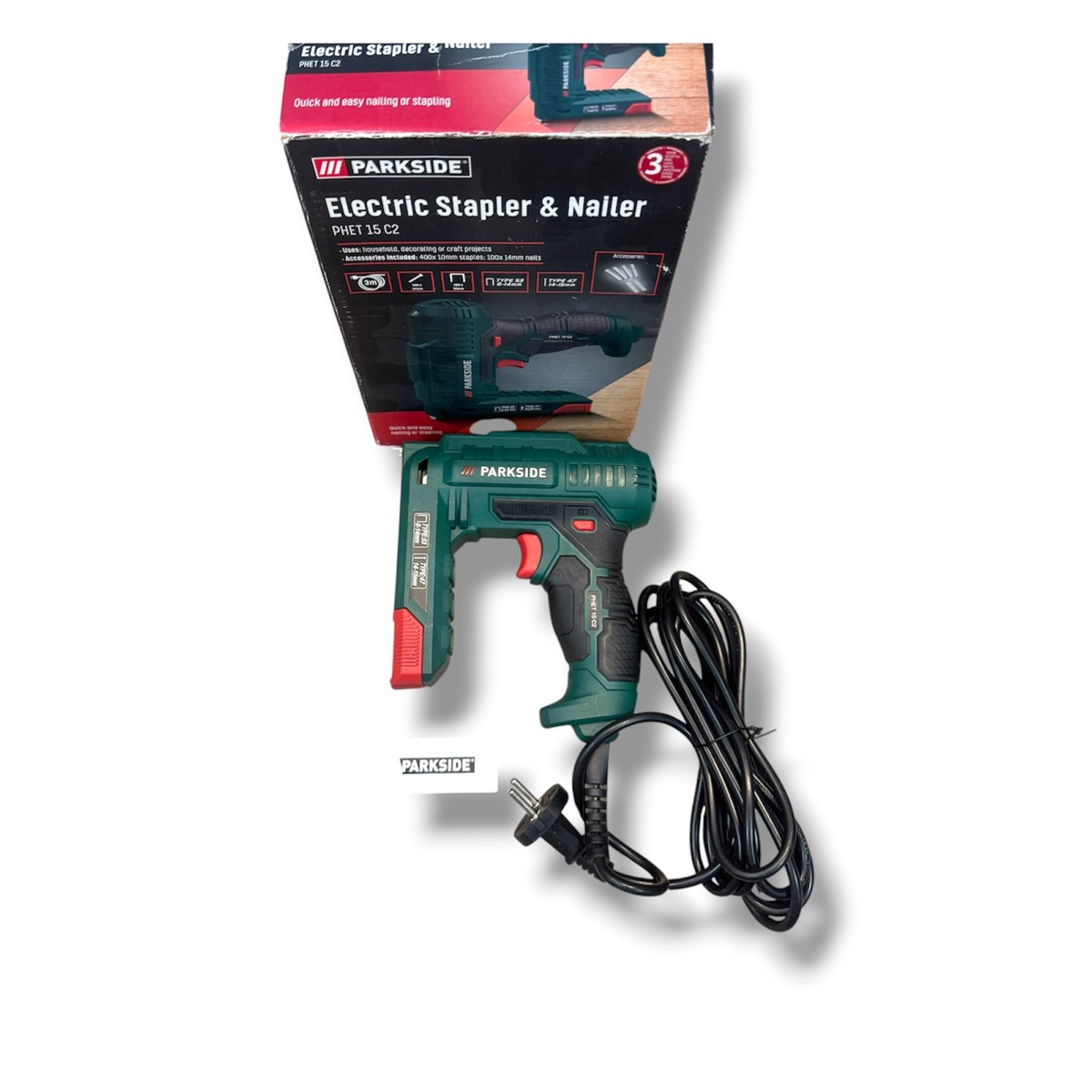 13d174f046ab27dea31856182f70c617jpg - Mezola OÜ Green Parkside electric stapler and nailer with red trigger, corded, pictured with its box in the background.