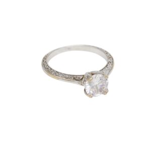 Silver ring with a large round-cut diamond solitaire and an engraved, scroll-patterned band.