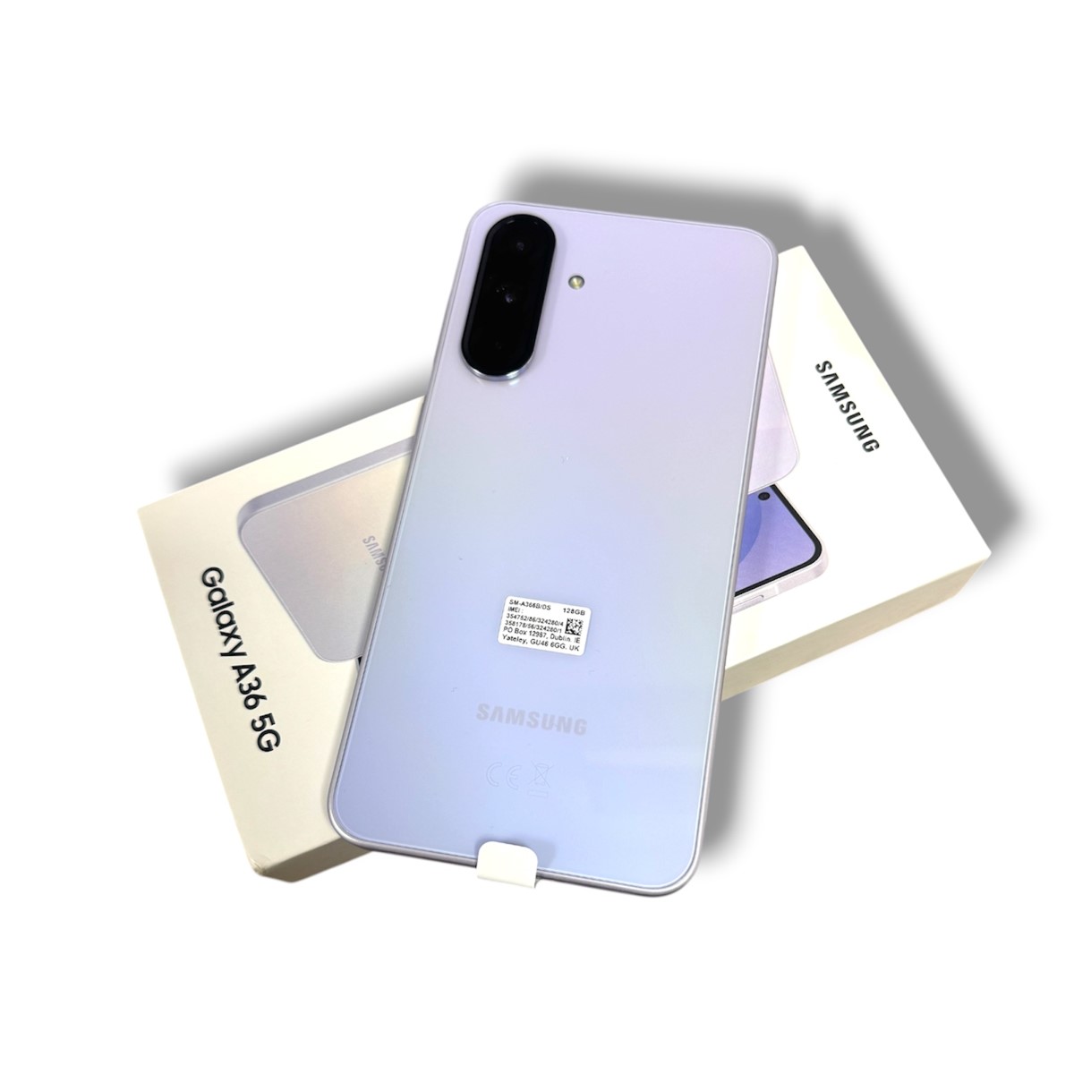 404777448dfbec46e299c4da044efe92jpg - Mezola OÜ Back of a lavender Samsung Galaxy A36 5G phone with a vertical camera module placed on its white box.