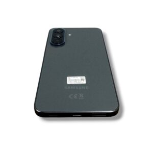 Back view of a dark gray Samsung smartphone with a triple-camera module in the top-left corner and regulatory marks on the back