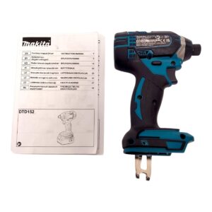 Makita cordless impact driver with instruction manual beside it, showing a teal and black drill and a printed manual