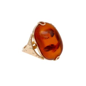 Gold ring with a large oval amber gemstone set in an ornate gold band.