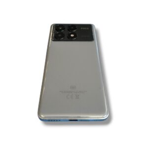 Back of a silver POCO smartphone with a quad-camera module and 5G emblem visible on the top left area of the camera panel.