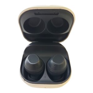 Open beige charging case with two black wireless earbuds inside.