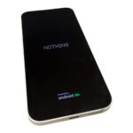 Smartphone with a black screen showing the word NOTHING and an Android logo at the bottom.