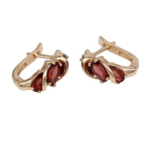 Gold-tone clip-on hoop earrings with maroon teardrop-cut stones secured by claw settings