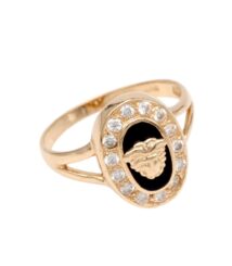 Gold ring with black oval centerpiece showing a raised decorative emblem, encircled by clear rhinestones on a polished band.