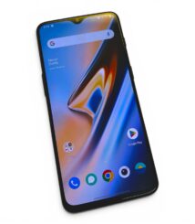 Tilted smartphone displaying home screen with Google search bar and app icons (Google Play, Chrome) on a colorful wallpaper
