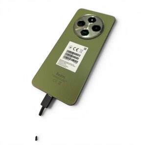 Green Redmi smartphone back with circular triple-camera module and attached charging cable, angled on white background.