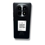 Back view of a black Redmi smartphone showing a square quad-camera module and a sticker on the back.