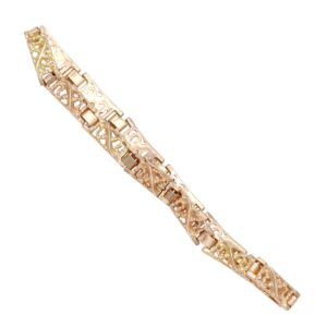 Gold-tone bracelet with decorative filigree openwork links and rectangular connectors.