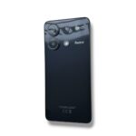 Back of a black Redmi smartphone with a triple-camera cluster and flash near the top-left corner