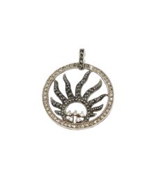 Circular sunburst pendant with inner black stone rays and a dotted outer ring set with small clear stones, on a bail.