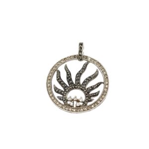 Circular sunburst pendant with inner black stone rays and a dotted outer ring set with small clear stones, on a bail.