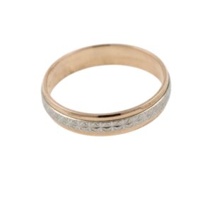 Close-up of a two-tone metal ring with an intricate geometric floral pattern along the outer band.