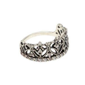 Silver filigree ring with small clear stones arranged along a decorative lace-like band