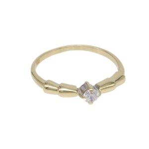 Gold ring with a small round diamond set in a prong setting at the center and a slim decorative band on each side.