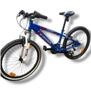 Blue mountain bike with front suspension, knobby tires, and a blue frame marked with 'KROS' on the downtube.