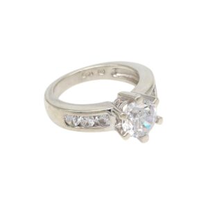 Engagement ring with a large central round diamond in a prong setting and three smaller diamonds along the band.