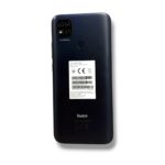 Back of a dark blue/black Redmi smartphone showing a quad-camera module labeled AI CAMERA and a round fingerprint sensor with a white sticker on the back, Redmi logo below.