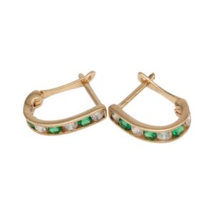 Gold-tone hoop earrings set with alternating emerald green and clear stones along the outer edge; hinged clasps visible.