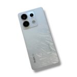 Back of a light-silver Redmi smartphone with a prominent square triple-camera setup in the top-left corner and a frosted gradient back.