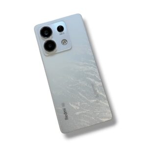 Back of a light-silver Redmi smartphone with a prominent square triple-camera setup in the top-left corner and a frosted gradient back.
