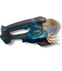 Blue cordless angle grinder with a protective guard and cutting disc, lying on its side.