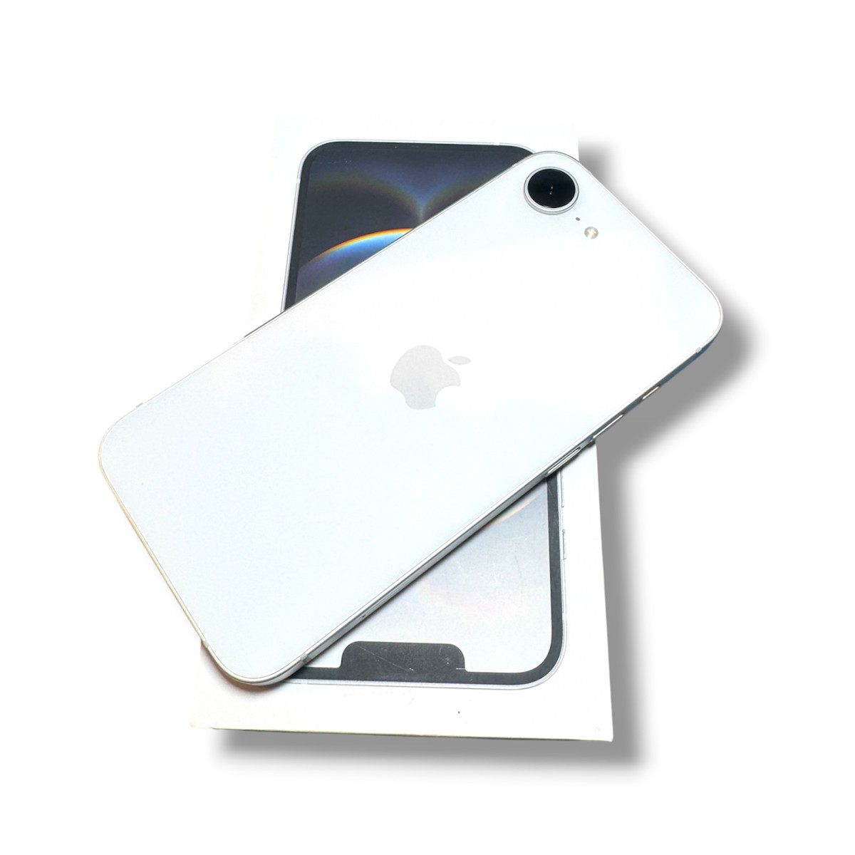 d30ee113ec9a107a3b8ce5c2300d8ae6jpg - Mezola OÜ White iPhone with Apple logo resting on its box, showing the rear camera in the top corner.