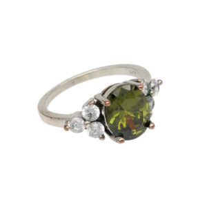 Silver ring with an oval olive-green center stone and surrounding small diamonds on a white metal band