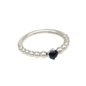 Silver beaded ring with a single dark blue bead at the front as centerpiece