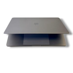 Closed silver MacBook on top of a second gray laptop, Apple logo visible on the lid