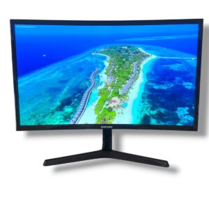Samsung curved monitor on a stand displaying a vivid aerial wallpaper of a tropical island and turquoise sea