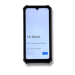 Smartphone with a black rugged case showing an initial setup screen reading 'Hi there' and options for language and vision settings, with a Start button.