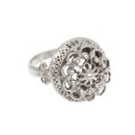 Silver ring with intricate floral filigree and beaded edge, close-up view