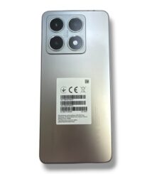 Back view of a silver smartphone with a rectangular quad-camera module in the top-left corner and a label on the back panel, no visible branding mentioned.