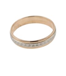 Close-up of a two-tone wedding band with a repeating floral geometric engraving in gold and silver tones.