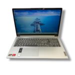 Open silver Lenovo laptop shown from a slightly elevated angle with a blue ocean pier wallpaper on the screen.