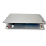 Slim silver Lenovo laptop partially open, exposing keyboard area with Ryzen stickers visible on the palm rest