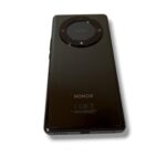 Rear view of a black HONOR smartphone with a circular camera module at the top center, high-gloss finish.