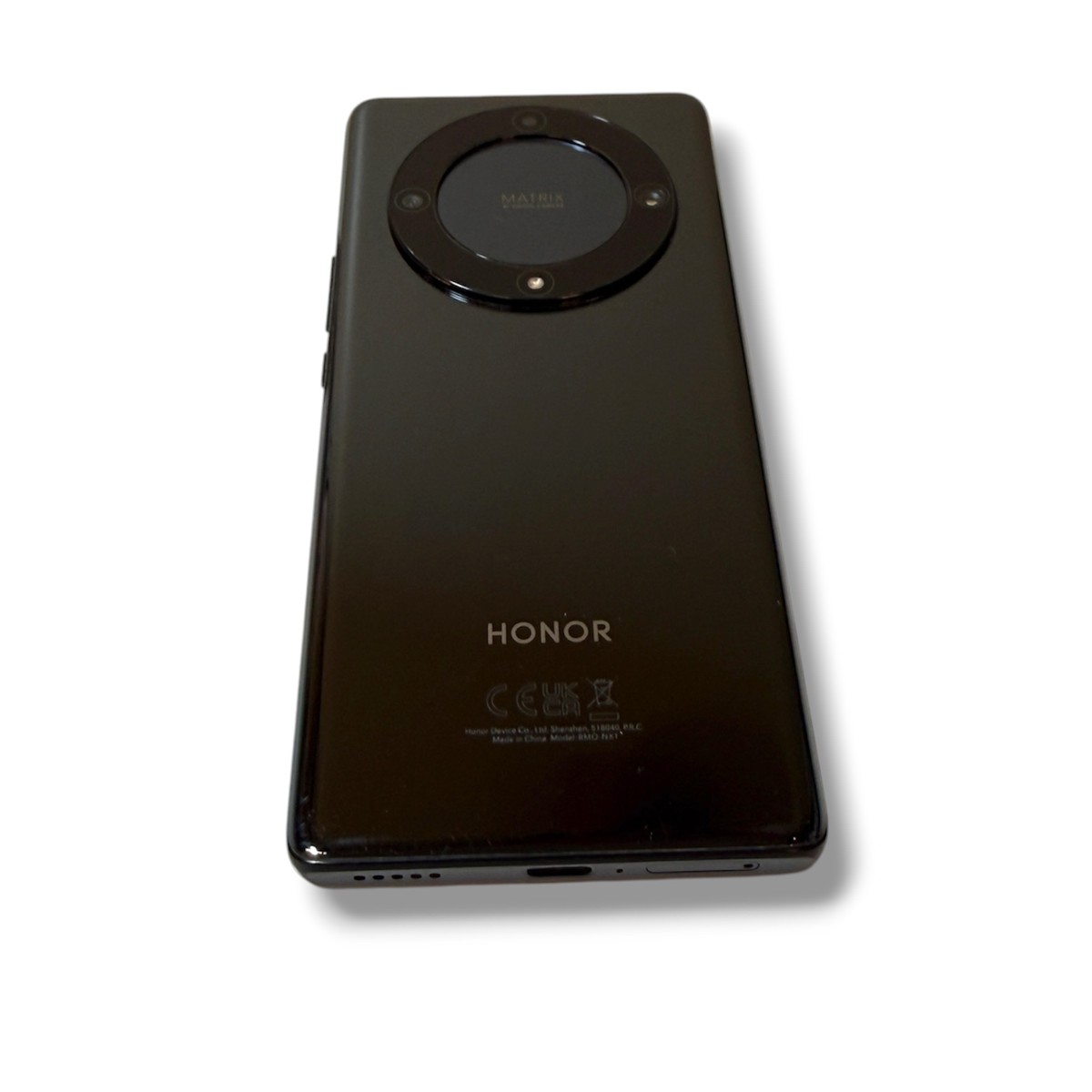 7d69a13fdb5edb3461e05b92d24ea1b2jpg - Mezola OÜ Rear view of a black HONOR smartphone with a circular camera module at the top center, high-gloss finish.