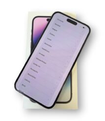 Smartphone resting on its box, screen showing a list of languages (e.g., Ελληνικά, Română, Magyar).